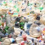 Large pile of discarded plastic bottles and containers in various colors, illustrating plastic waste and pollution