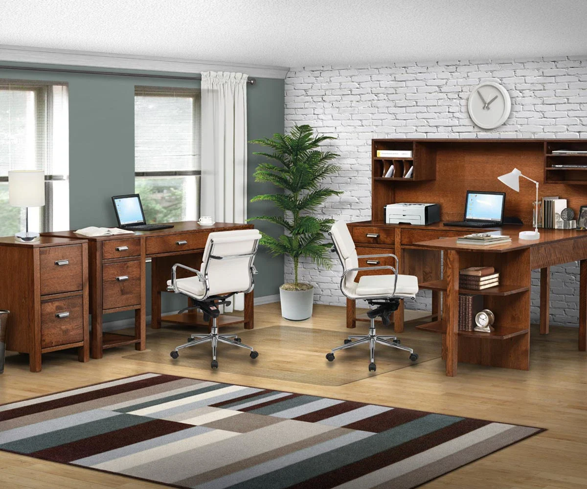 Amish Wakefield office collection staged with wood desks and hutches against a white brick wall.
