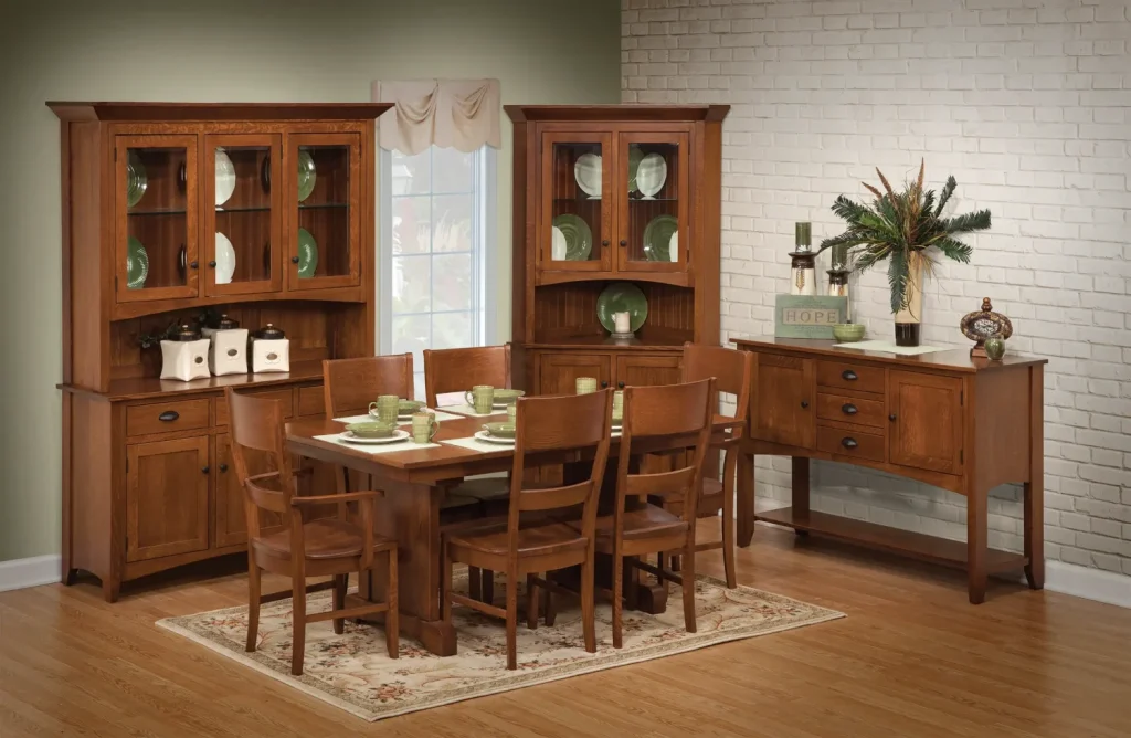 Amish Sara Ann dining collection in oak, shown in a green-walled room with a table, chairs, corner hutches, and a sideboard.