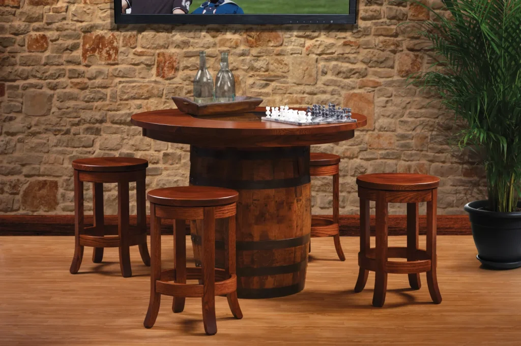Amish Barrel dining collection shown against a stone wall with a whiskey-barrel pub table and saddle stools.