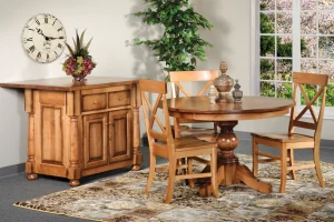 Amish Kimberly dining collection in light oak, staged with a round pedestal table, chairs, and a kitchen island.