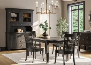 Amish Newbury dining collection in a black finish, staged with a table, chairs, hutch, and server under a chandelier.